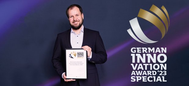 Smiling EXCOR employee presents the German Innovation Award certificate
